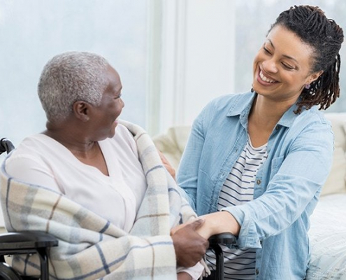 A smiling Family Caregiver looking at their aging parent.